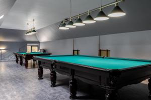 two pool tables in a billiard room with lights at Saltzbork Resort&Spa in Staraya Popa