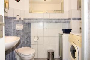 a bathroom with a toilet and a sink and a washing machine at Ferienwohnung, Trassenheide in Trassenheide +30 photos