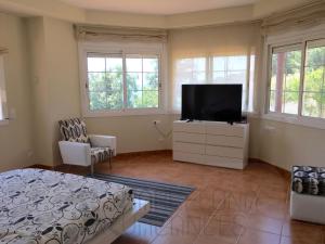 a bedroom with a flat screen tv on a dresser at BarcelonaVacances-Villa Lucia in San Pol de Mar