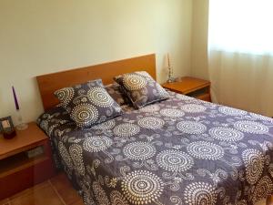 a bed with a blue and white comforter and pillows at BarcelonaVacances-Villa Lucia in San Pol de Mar +35 photos