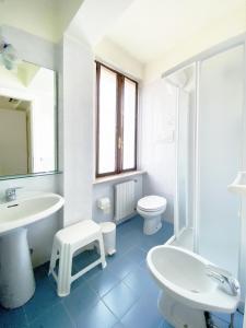 a white bathroom with a sink and a toilet at Hotel Alla Torre in Garda