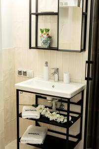 a bathroom with a white sink and a mirror at Maya's Flats & Resorts 40 - Kolodziejska 7/9E in Gdańsk