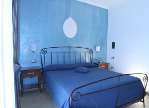 a blue bedroom with a bed and a blue wall at Hotel Boutique Il Castellino Relais in Vieste
