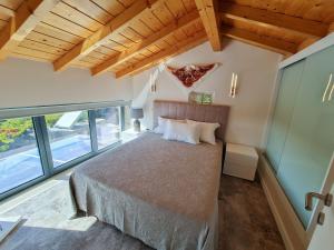 Un dormitorio con una cama grande en una habitación con ventanas. en Quinta dos Fangueiros, en Riba de Âncora 67 fotos más