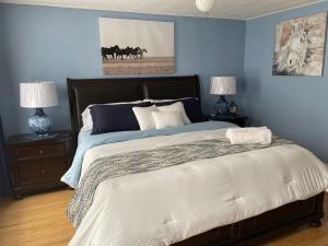 a bedroom with a large bed with blue walls at THE YORK HOUSE in Fort Erie