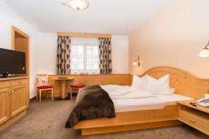 a hotel room with a bed and a television at Hotel Montana in Ischgl