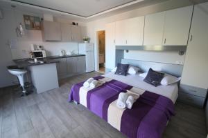 a bedroom with a large bed and a kitchen at Apartments Viola in Tučepi