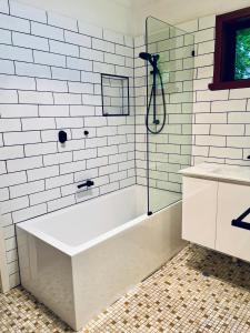 a white bathroom with a tub and a sink at Peace Retreat Bright in Bright