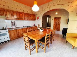 a kitchen with a wooden table and chairs at Wilga Summit Apartment A in Qala