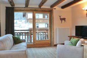 a living room with a sliding glass door with a deer on the wall at Appartamenti Diva in Livigno