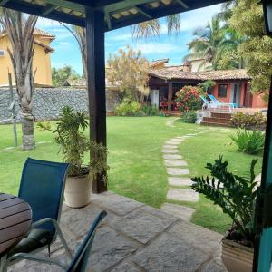 eine Terrasse mit Stühlen und einen Hof mit einem Haus in der Unterkunft Casa Buzios Geriba in Búzios
