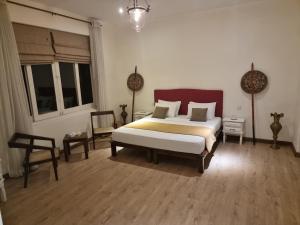 a bedroom with a bed and a table and a chair at Artisan Villa in Colombo