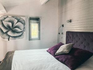 a bedroom with a bed with a flower painting on the wall at Auberge Des Pins in Tourrettes