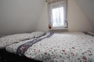 a bed with a floral comforter in a bedroom at Holiday home on Dümmer See, Perlin in Perlin