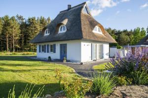 a white cottage with a thatched roof at Holiday house, Fuhlendorf in Fuhlendorf