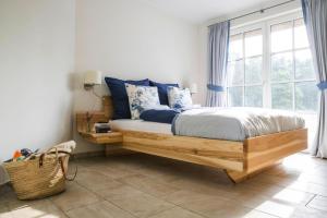 Un dormitorio con una cama con almohadas azules y una ventana en Holiday house, Fuhlendorf en Fuhlendorf