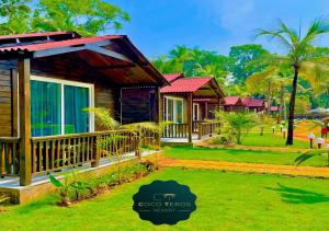 een resort met een groene tuin met huizen bij Coco Teros Resort in Mandrem