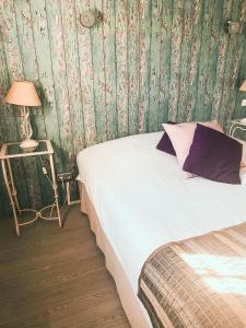 a bedroom with a bed and a table with a lamp at Auberge Des Pins in Tourrettes