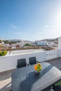 a table with a bowl of fruit on a balcony at #074 Casa dos Arcos by Home Holidays in Albufeira
