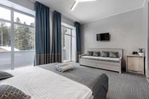 a bedroom with a bed and a couch and windows at Saltzbork Resort&Spa in Staraya Popa +51 photos