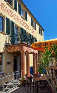 a building with a table and chairs in front of it at Das Muldenschlösschen - Gästehaus & Restaurant in Lunzenau