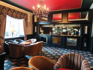 a restaurant with a bar with chairs and a chandelier at Park House Hotel in Blackpool