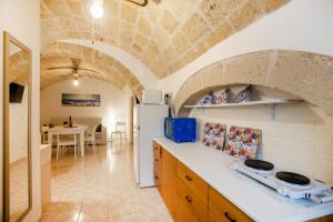 a kitchen with a stone ceiling and a white refrigerator at Monopoli Heartbeat - Apartment 200m from Sea in Monopoli