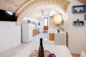 a kitchen with a table with a bottle of wine at Monopoli Heartbeat - Apartment 200m from Sea in Monopoli