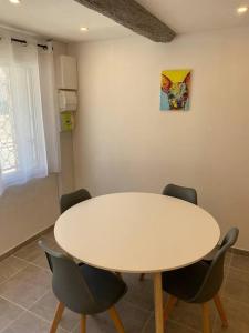 una mesa blanca y sillas en una habitación en Superbe Appartement climatisé avec Patio, en Montpellier