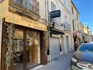 una tienda en una calle de la ciudad con un coche aparcado fuera en Superbe Appartement climatisé avec Patio, en Montpellier