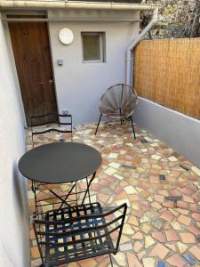un patio con mesa y sillas en un suelo de mosaico en Superbe Appartement climatisé avec Patio, en Montpellier