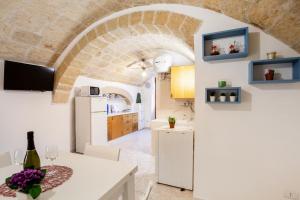 a kitchen and dining room with an archway at Monopoli Heartbeat - Apartment 200m from Sea in Monopoli