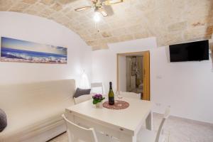 a room with a bed and a table with a bottle of wine at Monopoli Heartbeat - Apartment 200m from Sea in Monopoli