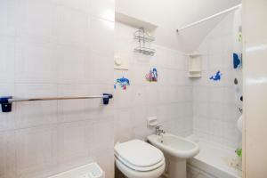a white bathroom with a toilet and a sink at Monopoli Heartbeat - Apartment 200m from Sea in Monopoli