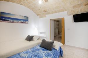 a bedroom with a bed and a flat screen tv at Monopoli Heartbeat - Apartment 200m from Sea in Monopoli