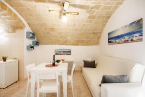 a dining room with a white table and chairs at Monopoli Heartbeat - Apartment 200m from Sea in Monopoli