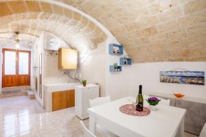 a kitchen and dining room with a white table and chairs at Monopoli Heartbeat - Apartment 200m from Sea in Monopoli