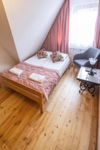 ein Schlafzimmer mit einem Bett, einem Stuhl und einem Fenster in der Unterkunft Moje Tatry Gluten Free in Biały Dunajec