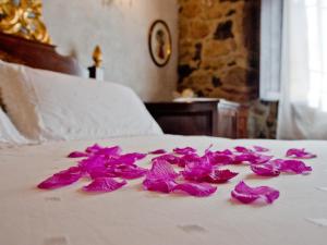 a pile of pink flowers on a bed at La Casa dels Poetes in Santa Pau