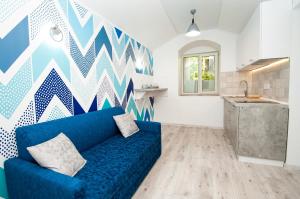 a living room with a blue couch and a geometric wall at Suites on Chaikovskogo in Odesa