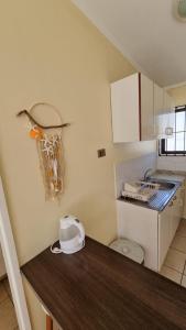 a small kitchen with a sink and a toilet at Cabañas Pinamar in La Serena