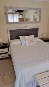 a bedroom with a large white bed with a star pillow at Cabañas Pinamar in La Serena