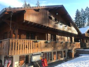 ein großes Holzgebäude mit Balkon im Schnee in der Unterkunft Chalet Esprit in Morillon