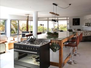 a kitchen and living room with a stove at Sunshowers Plett in Plettenberg Bay