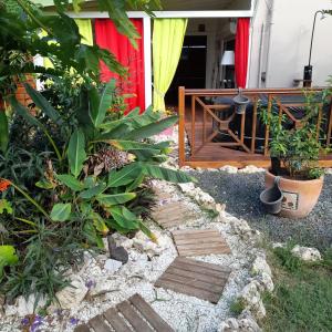 a garden with a wooden path in front of a house at Ti Colibri in Port-Louis