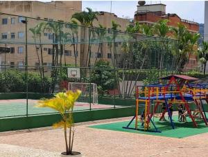 a playground with colorful equipment on a tennis court at Condomínio Itaparica III in Guarujá