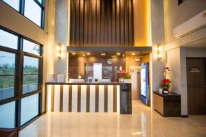 a lobby with a counter in the middle of a building at Kuda Asia Hotel Bang Saen in Bangsaen