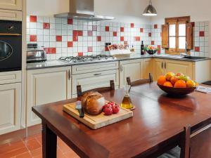 una cocina con una mesa de madera y un bol de fruta en Les Voltes, en Barbará