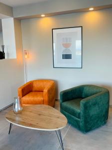 a living room with two chairs and a table at Hotel VIU57 in Mellieħa