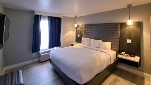 ein Hotelzimmer mit einem großen Bett und einem Fenster in der Unterkunft Clarion Pointe El Cajon San Diego East in El Cajon